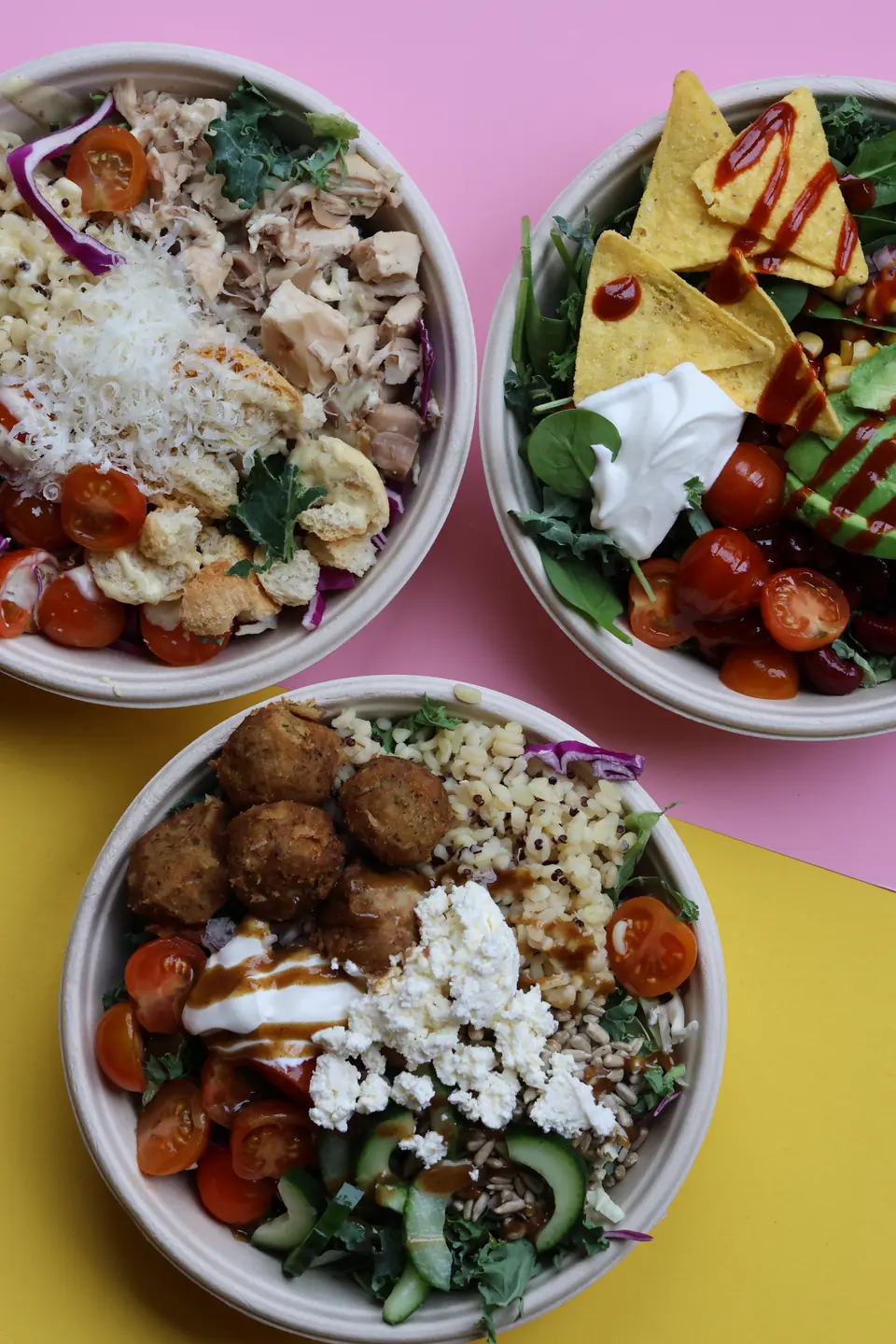 Drei Salat-Bowls mit Falafel, Hähnchen und Nachos