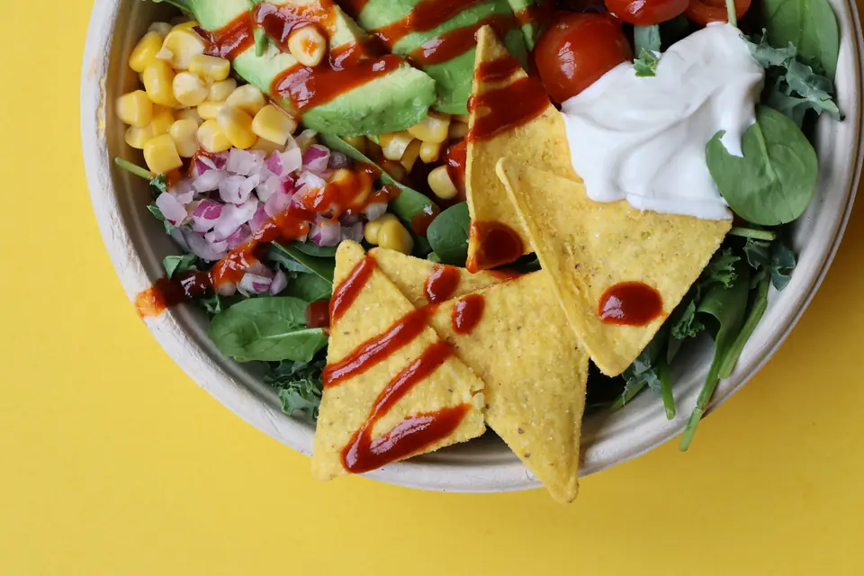 Bowl mit Nachos, Avocado und Sauerrahm